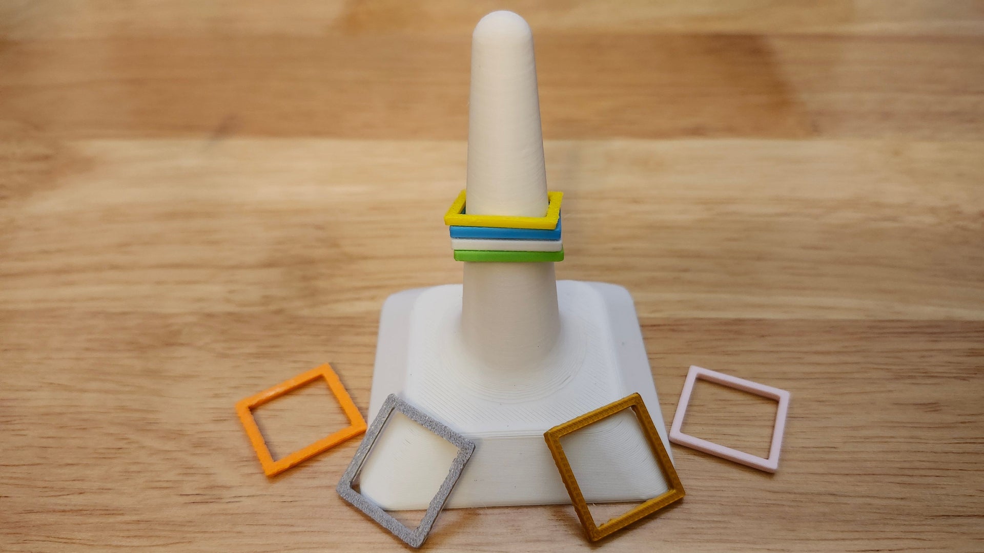 Eight Square Rings in different colors on a ring display stand