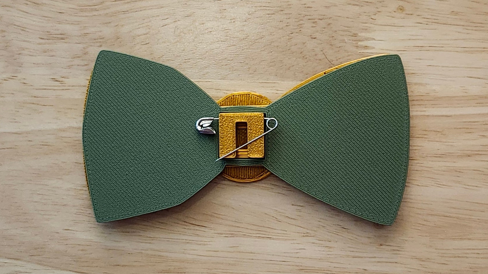 Money Bow Bundle Coin Button Cover, 100 Dollar Bill Bow, Gold Money Bow reverse side shown to demonstrate how to turn it in to a pin with the included safety pin. 3D printed for use as a bow tie, button cover, necklace, pin, hat pin, lapel pin and so much more. 