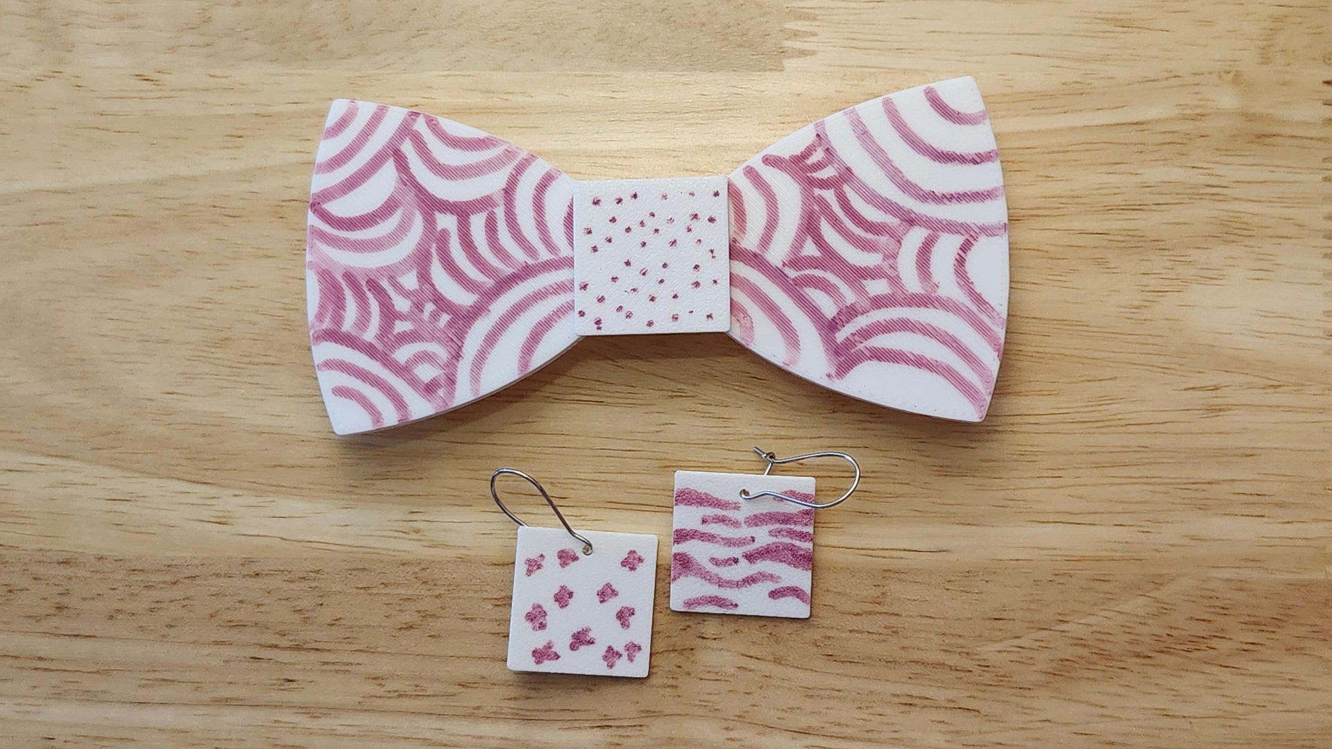 Bespoke It Yourself/Solid White Bow Bundle decorated sample including Square Button Cover and Blank Bow with matching Square earrings. 3D printed then hand colored by the customer for use as a bow tie, button cover, necklace, pin, hat pin, lapel pin and so much more.