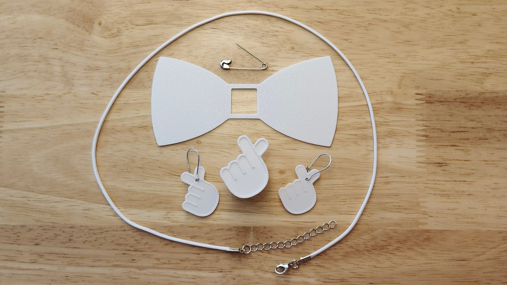 Bespoke It Yourself/Solid White Bow Bundle including K-pop/Hand Heart Button Cover and Blank Bow, matching K-pop/Hand Heart earrings, a safety pin and white necklace. 3D printed for use as a bow tie, button cover, necklace, pin, hat pin, lapel pin and so much more. 