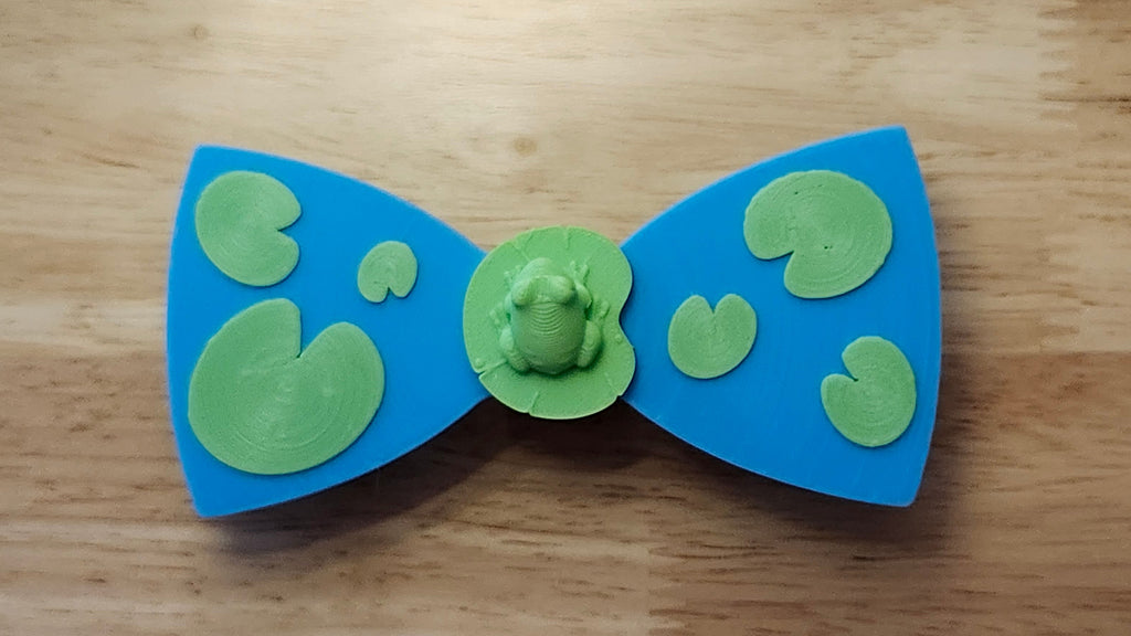 Frog Button Cover with Lily Pad Bow. 3D printed for use as a bow tie, button cover, necklace, pin, hat pin, lapel pin and so much more. 