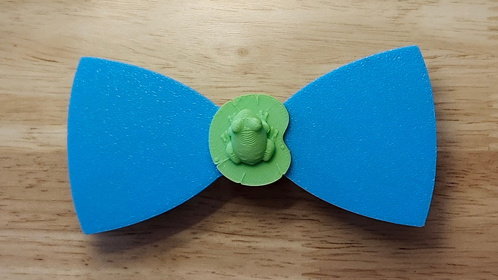 Frog Button Cover with Lily Pad Bow (reverse side). 3D printed for use as a bow tie, button cover, necklace, pin, hat pin, lapel pin and so much more. 