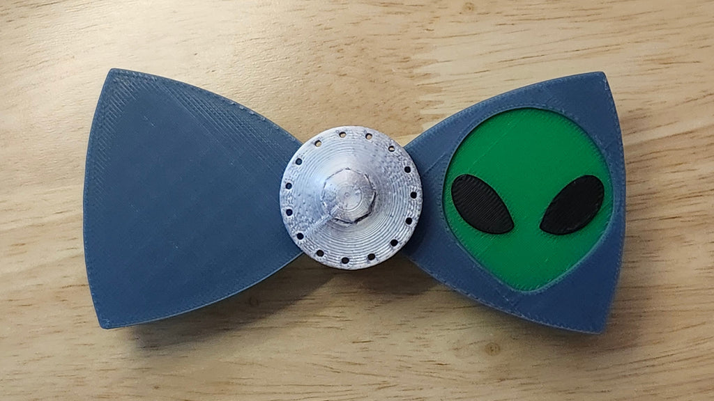 UFO Button Cover with Alien Head Bow. 3D printed for use as a bow tie, button cover, necklace, pin, hat pin, lapel pin and so much more.