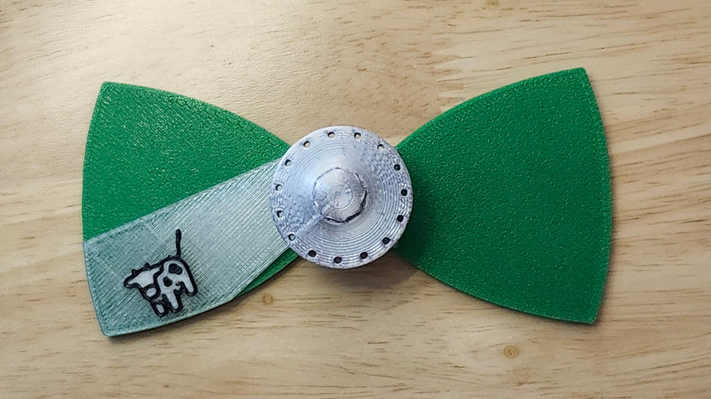 UFO Button Cover with Alien Head Bow (reverse side shown) and Cow Beaming Back. 3D printed for use as a bow tie, button cover, necklace, pin, hat pin, lapel pin and so much more.