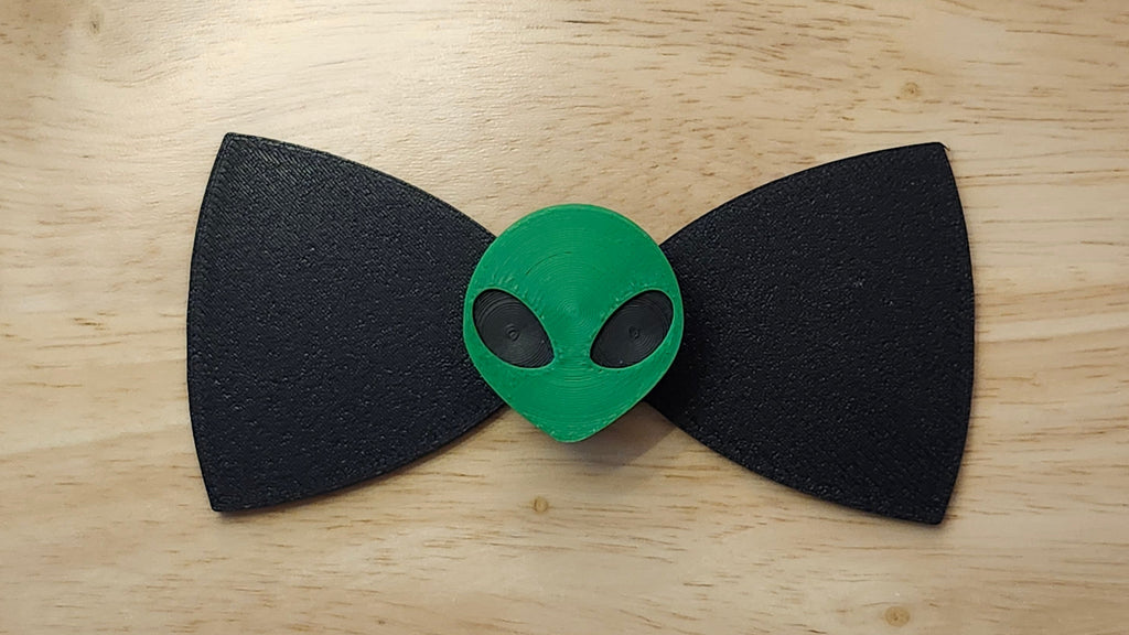 Alien Head Button Cover with Alien Peace Hand Bow (reverse side). 3D printed for use as a bow tie, button cover, necklace, pin, hat pin, lapel pin and so much more.