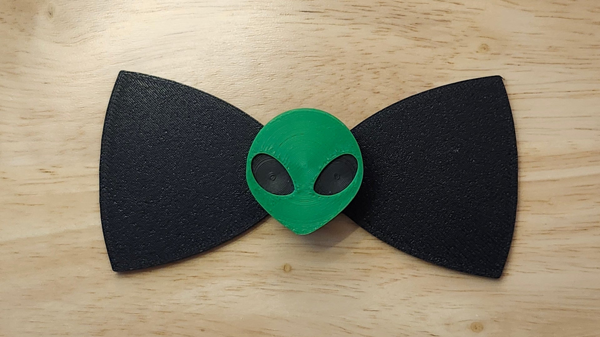 Alien Head Button Cover with Alien Peace Hand Bow (reverse side). 3D printed for use as a bow tie, button cover, necklace, pin, hat pin, lapel pin and so much more.