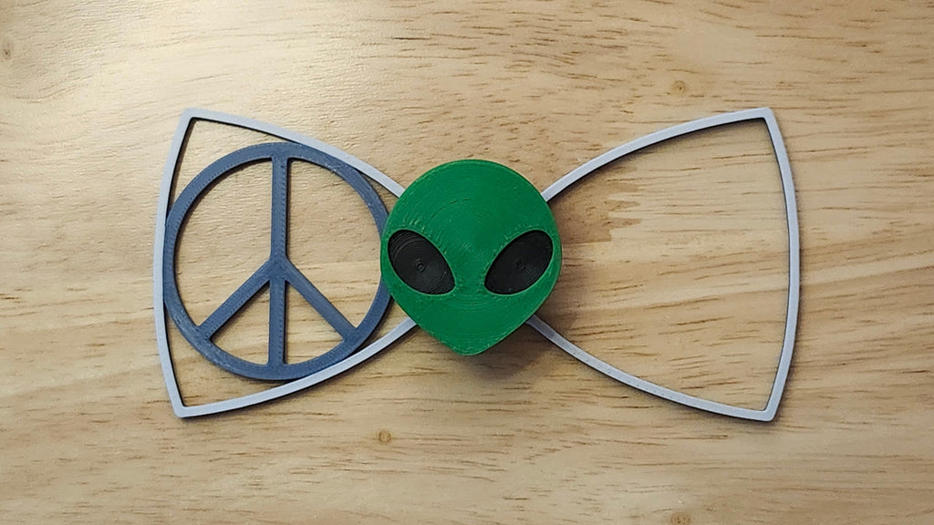 Alien Head Button Cover with Peace Sign Bow (two tone side shown). 3D printed for use as a bow tie, button cover, necklace, pin, hat pin, lapel pin and so much more.