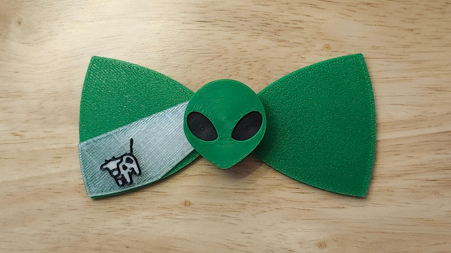 Alien Head Button Cover with Alien Head Bow (reverse side shown) and Cow Beaming Back. 3D printed for use as a bow tie, button cover, necklace, pin, hat pin, lapel pin and so much more.