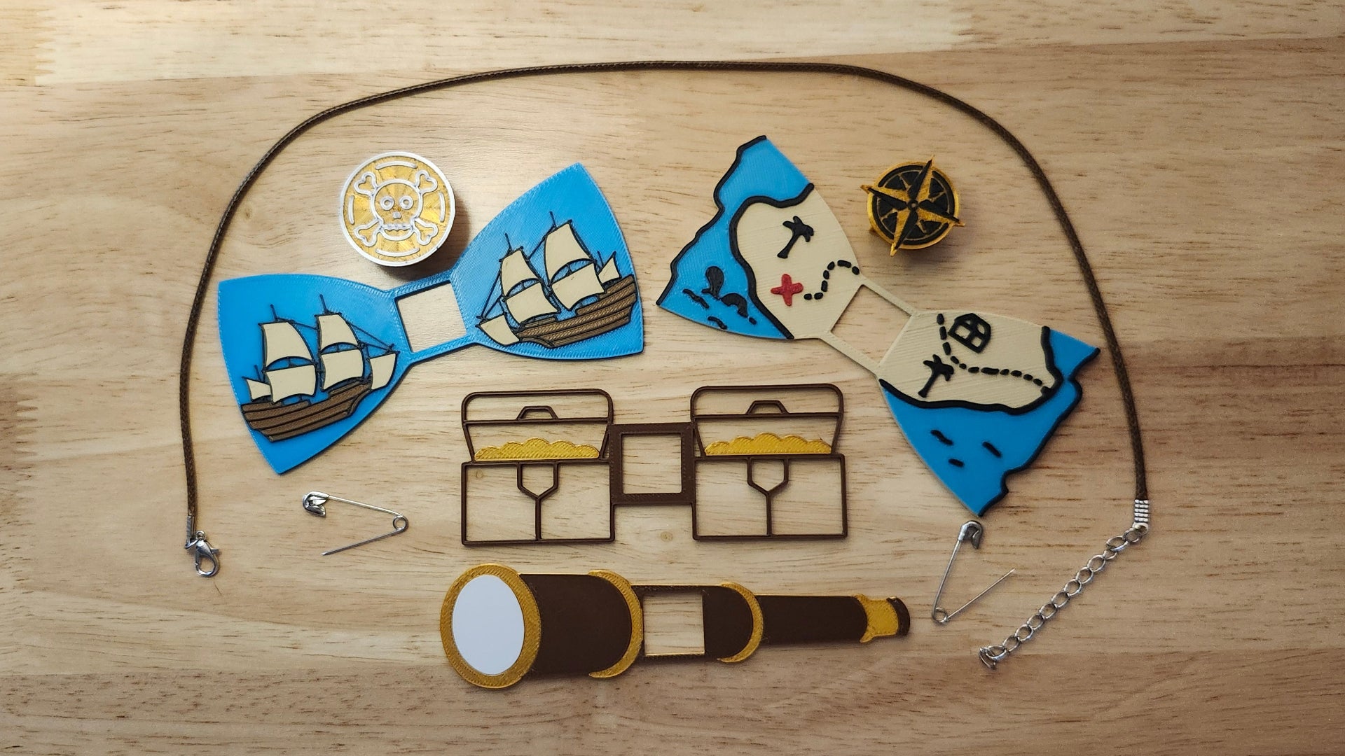 Pirate Booty Bow Big Bundle including the Compass Button Cover, Treasure Map Bow, Treasure Chest Back, Doubloon Button Cover, Ship Bow, Spyglass Back, 2 safety pins and an 18 inch brown necklace. 3D printed for use as a bow tie, button cover, necklace, pin, hat pin, lapel pin and so much more.