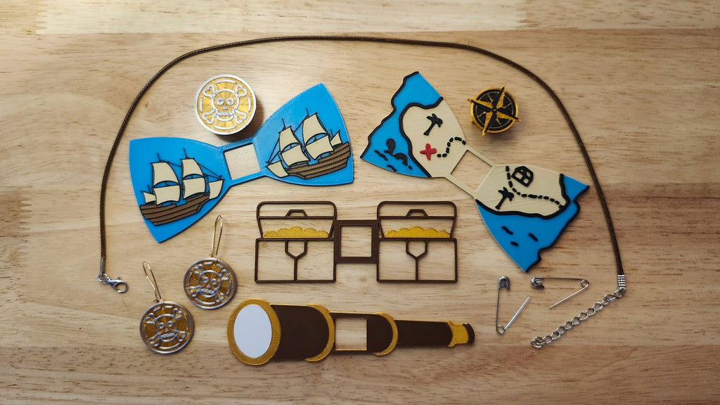 Pirate Booty Bow Big Bundle including the Compass Button Cover, Treasure Map Bow, Treasure Chest Back, Doubloon Button Cover, Ship Bow, Spyglass Back, matching Doubloon earrings, 2 safety pins and an 18 inch brown necklace. 3D printed for use as a bow tie, button cover, necklace, pin, hat pin, lapel pin and so much more.