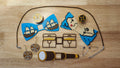 Pirate Booty Bow Big Bundle including the Compass Button Cover, Treasure Map Bow, Treasure Chest Back, Doubloon Button Cover, Ship Bow, Spyglass Back, matching Doubloon earrings, 2 safety pins and an 18 inch brown necklace. 3D printed for use as a bow tie, button cover, necklace, pin, hat pin, lapel pin and so much more.