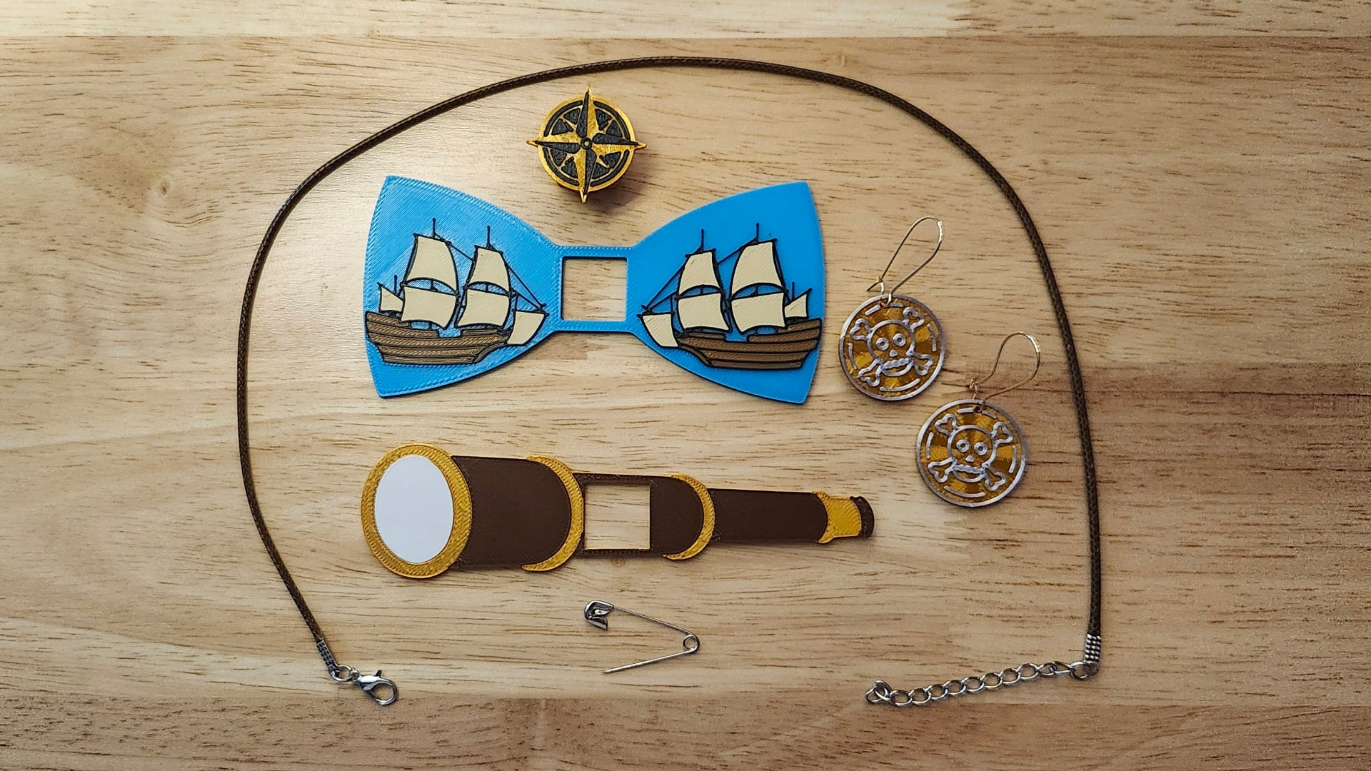 Pirate Ship Bundle including the Compass Button Cover, Ship Bow, Spyglass Back, matching Doubloon earrings, a safety pin and an 18 inch brown necklace. 3D printed for use as a bow tie, button cover, necklace, pin, hat pin, lapel pin and so much more.