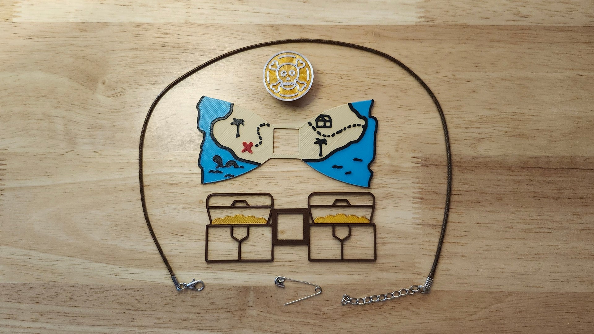Treasure Hunt Bundle including the Doubloon Button Cover, Treasure Map Bow, Treasure Chest Back, a safety pin and an 18 inch brown necklace. 3D printed for use as a bow tie, button cover, necklace, pin, hat pin, lapel pin and so much more.