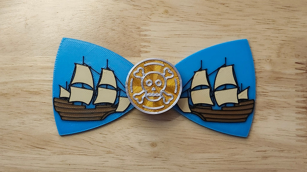 Doubloon Button Cover with Ship Bow. 3D printed for use as a bow tie, button cover, necklace, pin, hat pin, lapel pin and so much more.