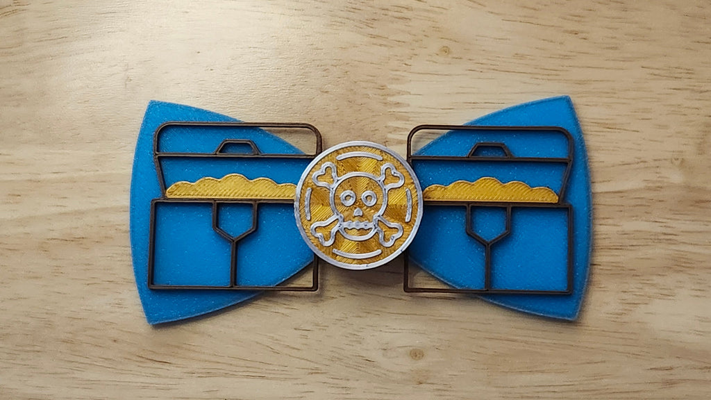 Doubloon Button Cover with Ship Bow (reverse side shown) and Treasure Chest Back. 3D printed for use as a bow tie, button cover, necklace, pin, hat pin, lapel pin and so much more.