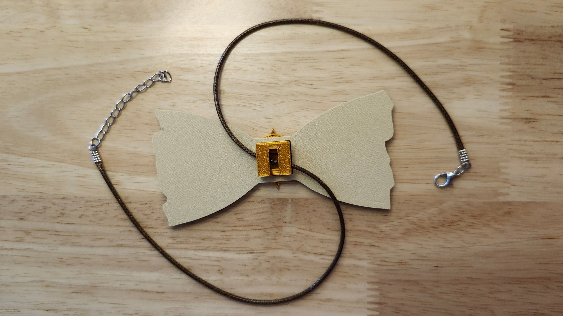 Compass Button Cover with Treasure Map Bow reverse side shown to demonstrate how it is worn with the included necklace. 